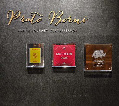 Prato Borni — Awards wall (Zermatterhof) Awards wall at Prato Borni, Grand Hotel Zermatterhof, showing Michelin star and GaultMillau recognition